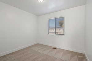 Unfurnished room with light colored carpet and baseboards
