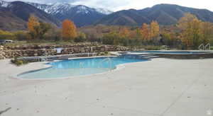 Community pool featuring a mountain view and a patio area
