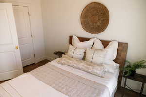 Bedroom with wood finished floors and baseboards
