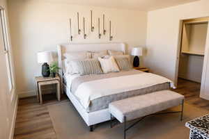 Bedroom featuring dark wood-style floors and baseboards