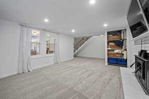Below grade area featuring carpet flooring, stairs, and recessed lighting