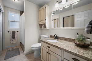 Full bath with vanity, curtained shower, and tile patterned flooring