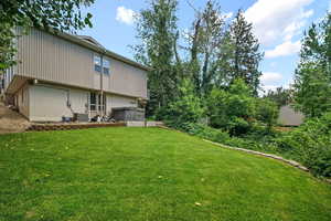 View of green lawn with an attached garage