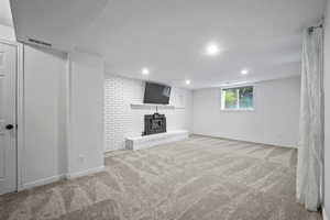Basement featuring a wood stove, carpet, and recessed lighting