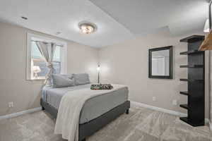 Bedroom with a textured ceiling and carpet