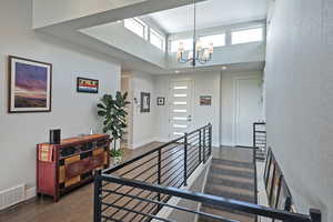 Stairway featuring a high ceiling, a chandelier, and wood finished floors