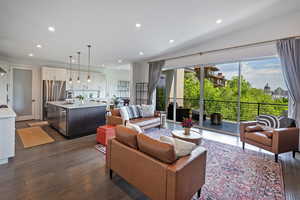 Living area featuring dark wood-style flooring, recessed lighting, and vaulted ceiling
