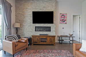 Living room featuring wood finished floors and a stone fireplace