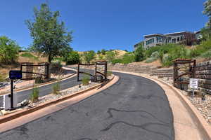 View of asphalt road with curbs and a gated entry