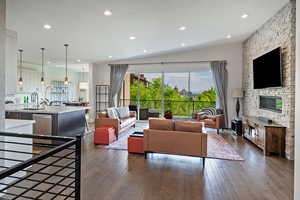 Living room featuring dark wood-type flooring, recessed lighting, and a fireplace