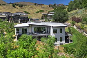Back of property featuring stucco siding, a balcony, and a mountain view