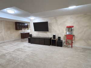 Finished below grade area featuring carpet floors and a textured ceiling