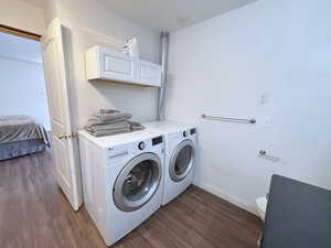 Laundry area with washing machine and dryer and wood finished floors