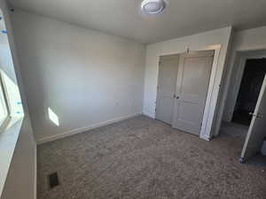 Unfurnished bedroom with carpet and a closet