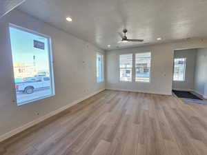 Spare room with light wood-style flooring, ceiling fan, a textured ceiling, and recessed lighting