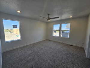 Empty room featuring a textured ceiling, carpet flooring, a ceiling fan, and recessed lighting