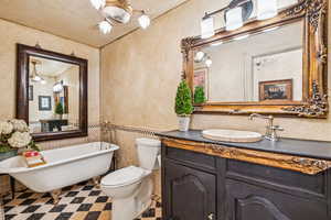 Bathroom with a freestanding tub, vanity, tile patterned floors, a wainscoted wall, and tile walls