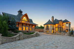 View of front facade featuring a chimney and stone siding