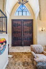 Entryway featuring lofted ceiling and a chandelier