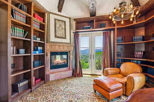 Sitting room with a tile fireplace, french doors, a chandelier, a mountain view, and carpet