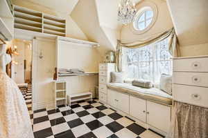 Bathroom with a chandelier and vaulted ceiling