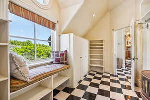 Living area with high vaulted ceiling and tile patterned floors