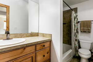 Bathroom with vanity, shower / bath combo, and tile patterned flooring