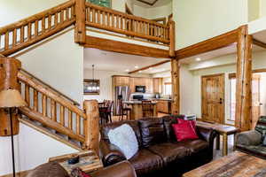 Living area with a chandelier, a towering ceiling, recessed lighting, and stairway
