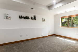 Spare room featuring carpet and baseboards