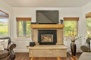 Living area featuring dark wood finished floors and a glass covered fireplace