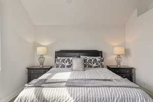 Bedroom featuring vaulted ceiling and carpet flooring