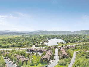 Aerial view of property's location featuring a water and mountain view and nearby suburban area