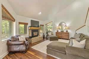 Living area featuring plenty of natural light, wood finished floors, a glass covered fireplace, and recessed lighting