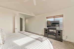 Unfurnished bedroom with lofted ceiling, carpet flooring, and a ceiling fan