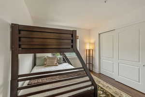 Bedroom with wood finished floors and a closet