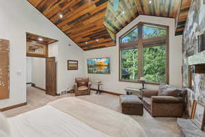 Carpeted bedroom featuring wood ceiling, high vaulted ceiling, a large fireplace, and recessed lighting
