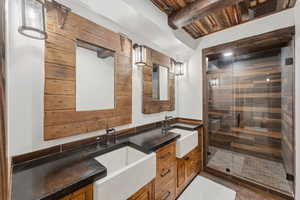 Full bathroom featuring double vanity, a relaxing sauna, a stall shower, a wooden ceiling with exposed beams, and tile patterned flooring