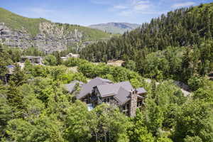 View of subject property featuring a mountain backdrop and a forest
