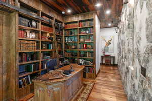 Home office with bookshelves and wood finished floors