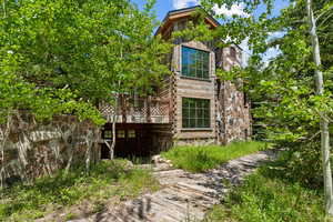 View of side of home featuring a wooden deck