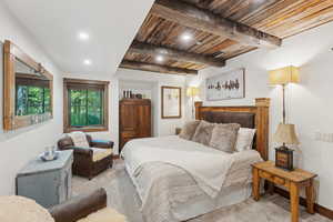 Bedroom with light carpet, recessed lighting, and a wood ceiling with exposed beams