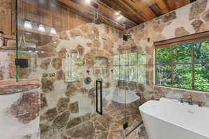 Bathroom featuring wooden ceiling, a marble finish shower, and a freestanding bath