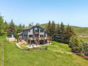 Back of property with a patio, a wooden deck, a yard, stairway, and stucco siding
