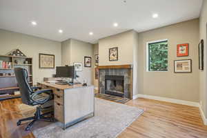 Home office featuring wood finished floors, a tile fireplace, and recessed lighting