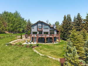 Back of house featuring a patio area, a wooden deck, stairs, and a chimney
