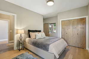 Bedroom with wood finished floors and a closet