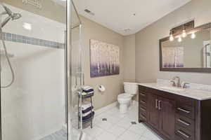 Full bath featuring vanity, a stall shower, and tile patterned flooring