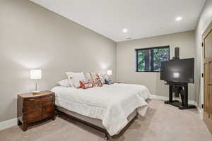 Bedroom with light colored carpet and recessed lighting