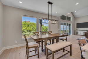 Dining room with plenty of natural light, recessed lighting, light wood-style flooring, and vaulted ceiling
