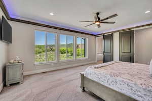 Carpeted bedroom featuring recessed lighting, a barn door, and a ceiling fan